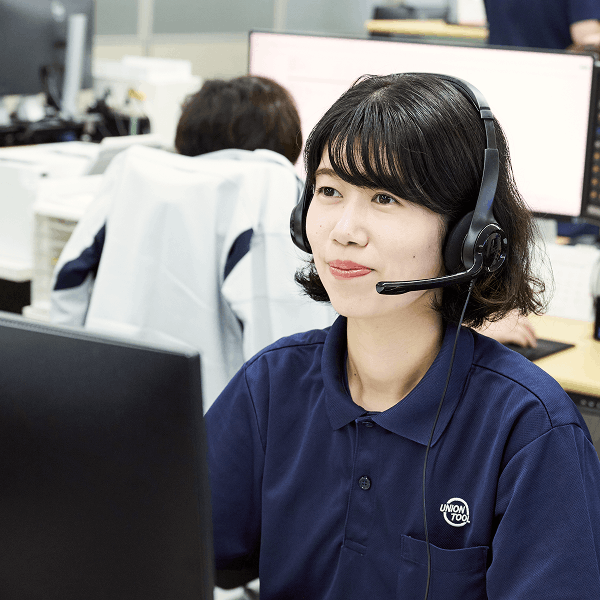 ヘッドセットを装着してオフィスで業務を行う女性社員