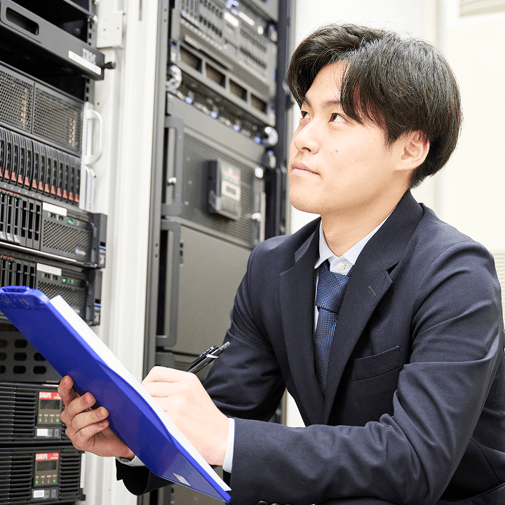 サーバールームで点検作業を行うシステム開発職の男性社員
